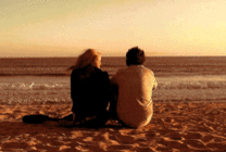 沙滩上的情侣遥望大海动态图片