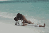 情侣躺在海边的沙滩上亲吻GIF动态图
