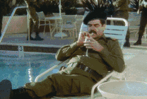 男人坐在游泳池旁边喝饮料接住炸弹GIF动态图