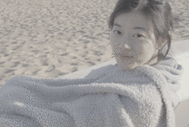 迷人的小女孩坐在沙发上用浴巾裹住自己GIF动态图片