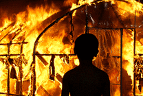男孩看着大火焚烧自己的家园GIF图片