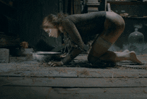 一位被铁链锁住的女人跪在地上喝水GIF图片