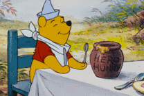 卡通小熊坐在桌子上享受美食gif图片