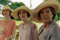 三个戴草帽的女人端着酒杯看向远方gif图片