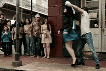一对情侣在马路边跳舞引来了一群人围观gif图片