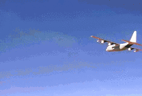 白色的飞机在沙漠的上空飞行gif图片