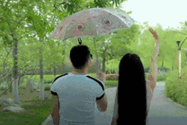 情侣在公园里打着雨伞散步gif图片