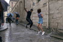 一对情侣在有积水的大街上蹦蹦跳跳gif图片