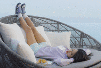 女孩躺在吊床上伸着腿睡觉GIF图片
