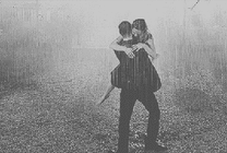 浪漫的情侣在大雨中拥抱转圈GIF图片