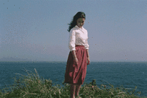女孩穿着裙子站在海边吹风gif图片